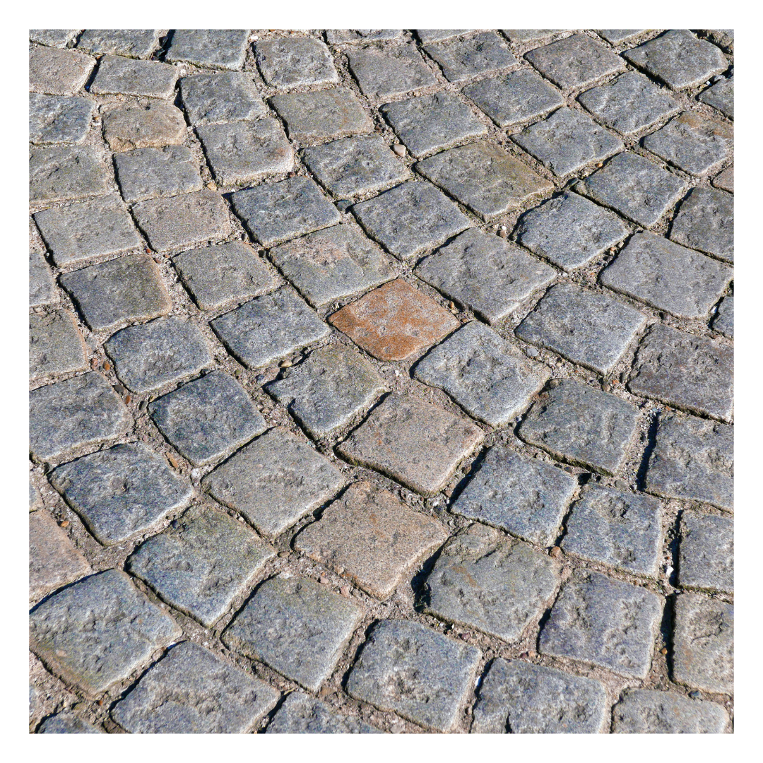 A detailed image of cobbled stones, showcasing their rounded and weathered appearance, ideal for decorative landscaping projects.